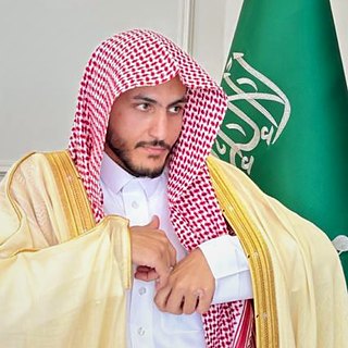 المحامي سالم خلف الشمري بالبشت، وبجانبه علم المملكة العربية السعودية